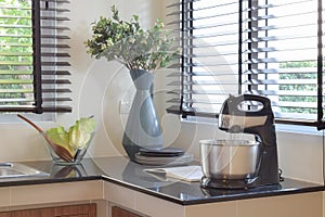 Modern ceramic kitchenware and utensils on the black granite countertop