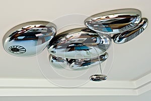 Modern chandelier in form of metal droplets
