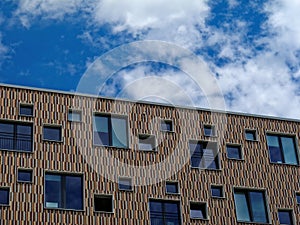 Modern checked pattern house facade by blue sky and white clouds