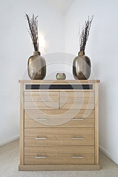 Modern chest of drawers with decorative vases