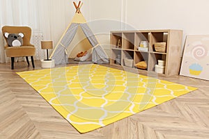 Modern children`s room interior with yellow carpet and stylish furniture