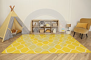 Modern children`s room interior with yellow carpet and stylish furniture