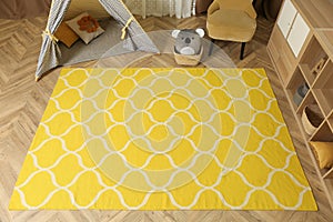 Modern children`s room interior with yellow carpet and stylish furniture, above view