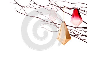 Modern Christmas ornaments hanging from frosty tree branches isolated on white