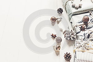 modern christmas wrapped presents with ornaments and toys on white wooden background top view, space for text. merry christmas co