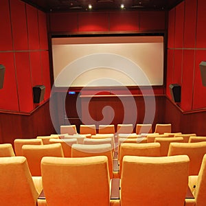 Modern cinema hall empty and beige comfortable seats, white cinema screen