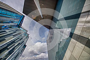 Modern city buildings in the business center, upward skyward view with clouds in the sky