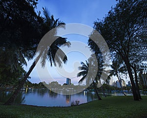 Modern city in a green environment at twilight, Suan Lum, Bangkok, Thailand.