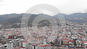 Modern city with residential buildings and hotels with mountains on background, aerial drone view. Tourist resort city Alanya, Tur