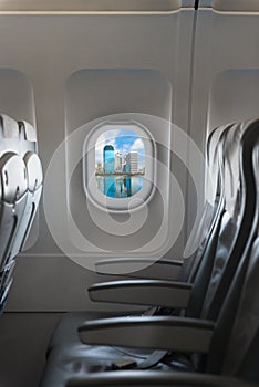 Modern city skyline through window on a commercial airliner airc