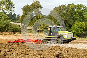 Modern claas tractor cultivating field