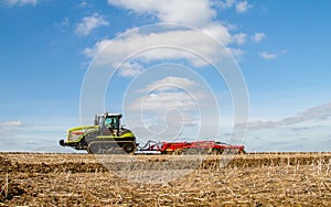 Modern claas tractor cultivating field