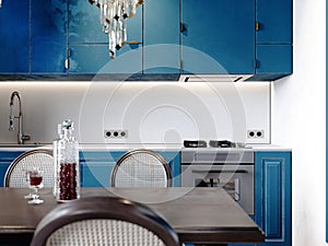 Modern classic kitchen with black dining table and chairs and light blue kitchen furniture and white walls