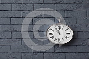 Modern clock on brick wall.