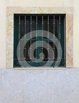 Modern closed window with vintage bars on clear wall, vertical o