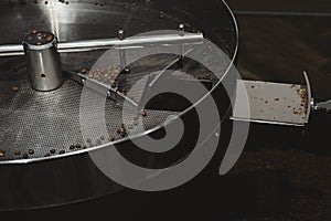 Modern coffee roaster machine with beans indoors, closeup