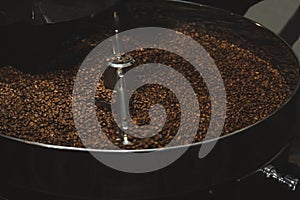Modern coffee roaster machine with beans indoors, closeup