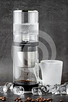 Modern Cold brew drip tower coffee maker on dark stone background