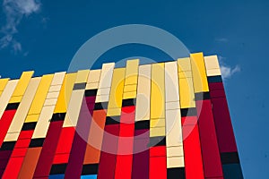 Modern colorful office building exterior with glass facade on clear sky background. Transparent glass wall of office