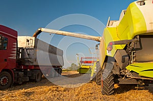 Modern combine harvester unloading grain in truck