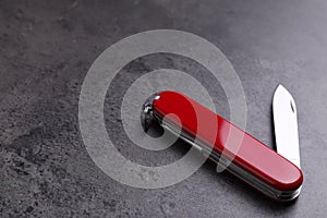 Modern compact portable multitool on grey table. Space for text