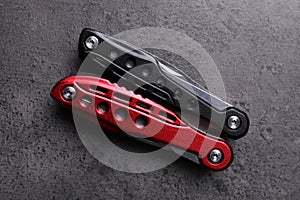 Modern compact portable multitool on grey table, top view