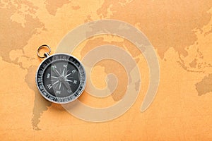 Modern compass on vintage world map. Travel planning concept