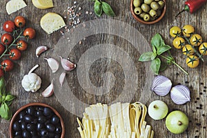 Modern composition of fresh food and ingredients on the vintage wooden table in the kitchen. Italian taste and look. Top view.