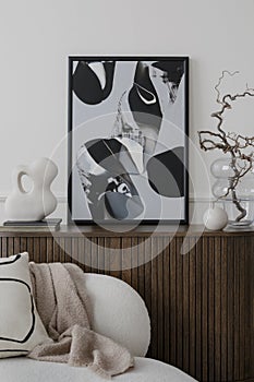 Modern composition of living room interior with mock up poster frame, wooden sideboard, glass vase with branch, sculpture, white