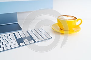 Modern computer desktop with yellow latte coffee cup