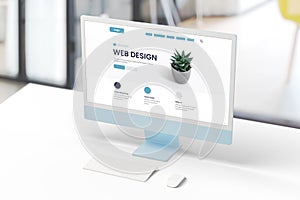 Modern computer display on an office desk with a web design studio concept page