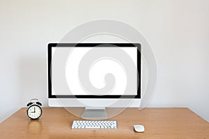 Modern computer with keyboard mouse and alarm clock on table