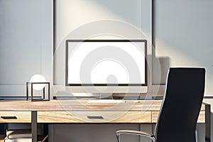 Modern computer monitor on office desk with geometric lamp and minimalist design. Professional workspace concept.