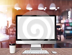 Modern Computer Monitor on a wooden desk with coffee shop