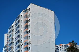 Modern concrete blocks apartment building with a deep blue sky background