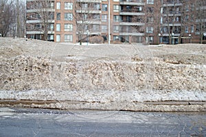 Modern condo buildings with huge windows and balconies and dirty snow