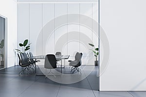 Modern conference room with empty poster, a table, chairs, and plants on a clean background, concept of a professional meeting