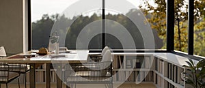 Modern contemporary dining room with dining table and low-corner bookcase against the window