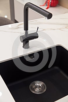 Modern and contemporary kitchen detail in luxury home, granite sink and black tap