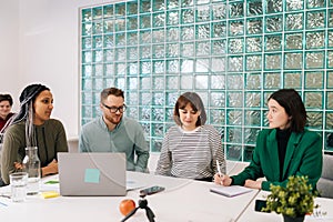 Modern corporate office open space with busy male and female staff employees using laptop computers sitting at work in