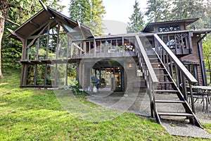 Modern countryside wooden house with big mirrored windows.