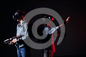 Modern couple playing video games wearing virtual reality glasses with controllers