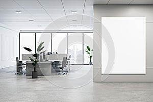Modern coworking office interior with blank white mock up banner on wall, panoramic windows and city view, daylight, concrete
