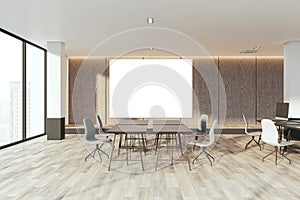 Modern coworking office interior with empty white mock up banner, concrete wall, wooden flooring, windows with city view, sunlight
