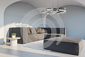 Modern cozy concrete living room interior with couch, decorative lamp and sunlight. Design concept.
