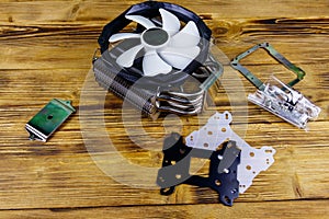 Modern CPU cooler with installation kit on wooden desk