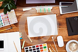 Modern creative design workplace with computer paints and mockup paper sheet