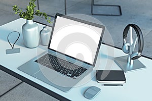 Modern creative designer desktop with laptop and white mock up space, decorative vase and supplies.