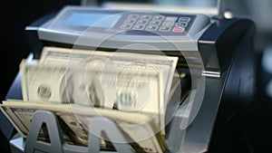 Modern currency counting machine counting dollar bills. Paper money calculation