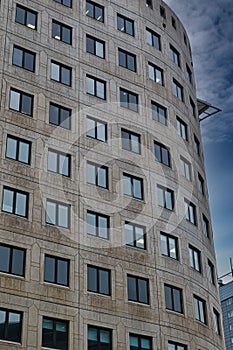 Modern curved office building facade against a clear blue sky in Leeds, UK